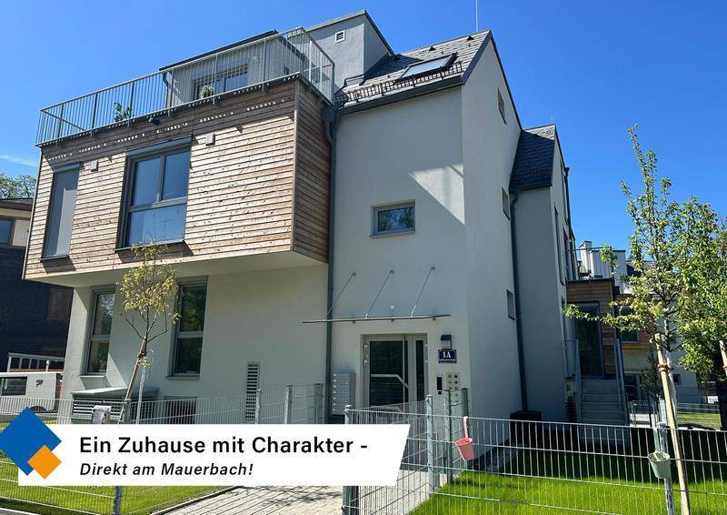 Moderne Wohnanlage mit ansprechender Architektur, Holzfassadenelementen und mehreren Balkonen unter blauem Himmel.