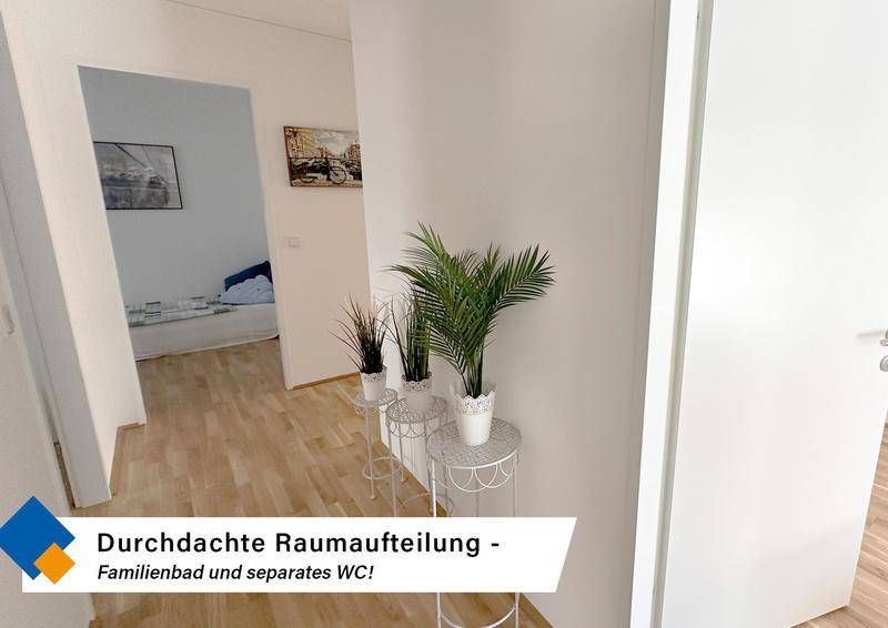 Heller Flur mit Holzboden und dekorativen Pflanzen, der zu den verschiedenen Räumen führt.