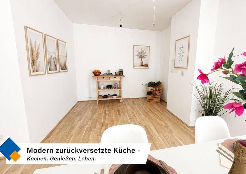 Moderner, zurückversetzter Küchenbereich mit hellem Holzboden und minimalistischer Einrichtung.