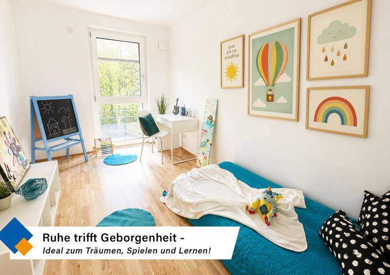 Freundliches Kinderzimmer mit hellem Holzfußboden, Schreibtisch und farbenfrohen Wanddekorationen.
