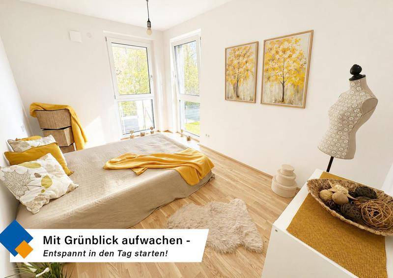 Helles Schlafzimmer mit Holzfußboden, großen Fenstern und einem beruhigenden Blick ins Grüne.