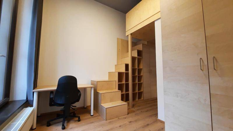 Helles Schlafzimmer mit Schreibtisch und clever integriertem Hochbett mit Stauraum.