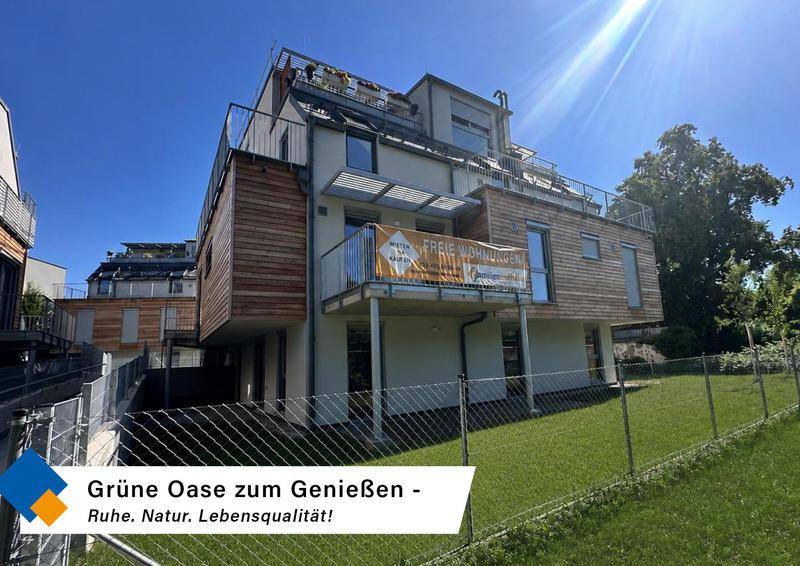 Attraktives Mehrfamilienhaus mit Holzfassade, Balkonen und gepflegtem Gartenbereich.
