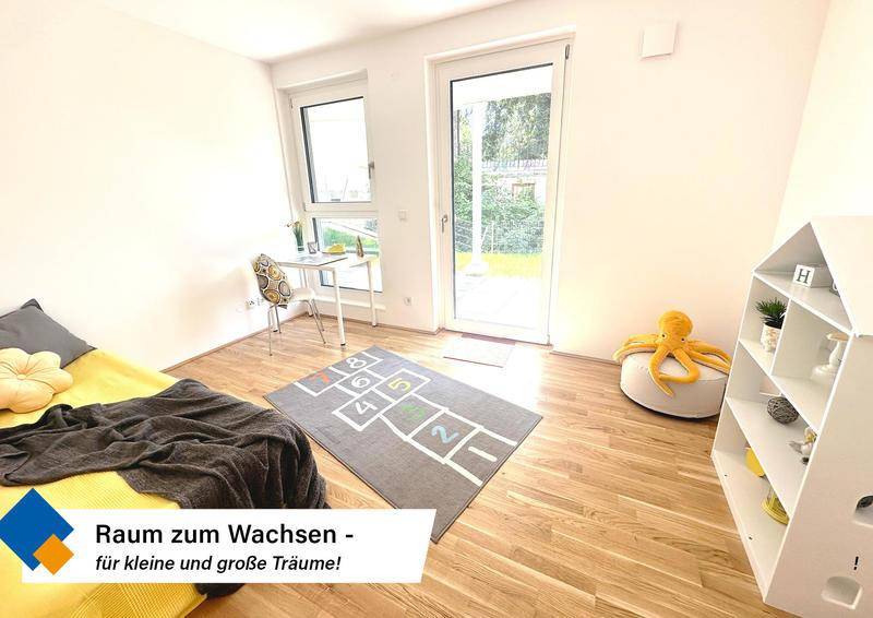 Freundliches Kinderzimmer mit Holzboden, Spielteppich und viel Tageslicht, perfekt zum Wachsen.