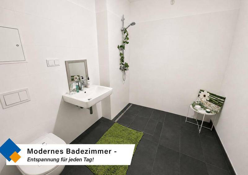 Modernes Badezimmer mit ebenerdiger Dusche, dunklen Fliesen und minimalistischem Design.