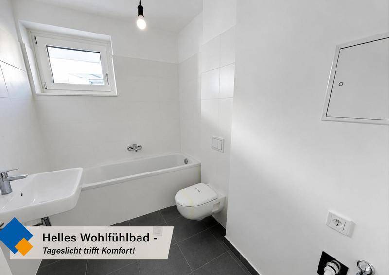 Helles Badezimmer mit Badewanne, wandhängendem WC, Waschbecken und Fenster für Tageslicht.