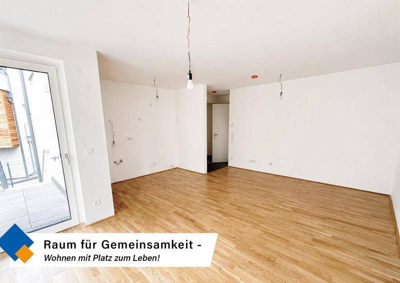 Weitläufiger Wohnbereich mit hellem Holzboden, ideal für individuelle Gestaltungsmöglichkeiten.