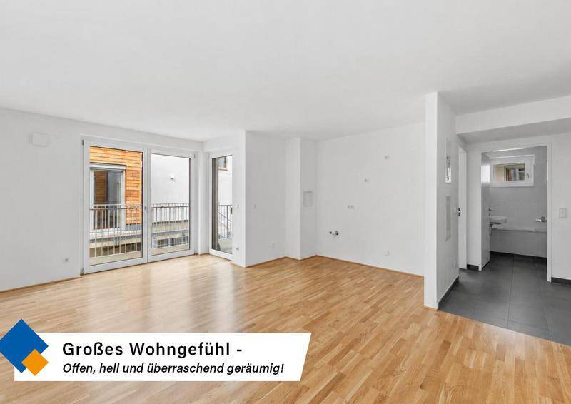 Geräumiger, heller Wohnbereich mit Holzboden und großem Zugang zu einem Außenbereich.
