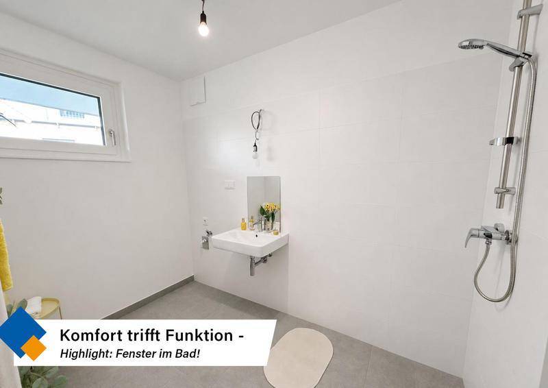 Helles Badezimmer mit Fenster, Dusche und Waschbecken, funktional und modern.
