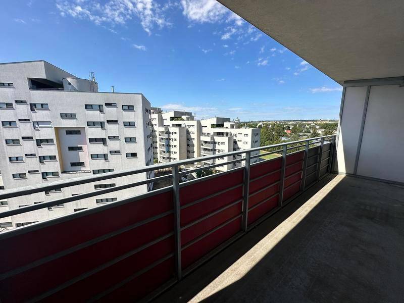 Heller Balkon mit weitem Blick über die Stadt und die moderne Architektur der Umgebung.