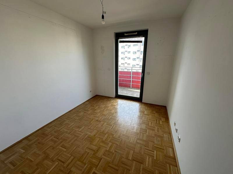 Helles Schlafzimmer mit Parkettboden und direktem Zugang zum Außenbereich.