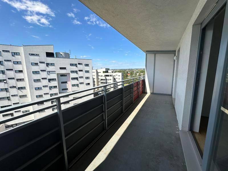 Heller Balkon mit moderner Brüstung und Weitblick über die Stadtlandschaft.