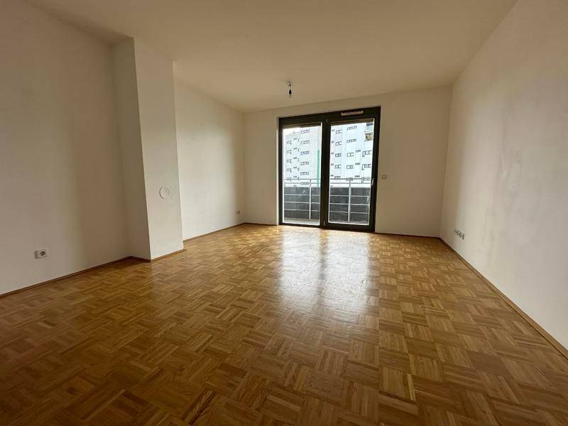 Geräumiges Wohnzimmer mit Parkettboden und viel natürlichem Licht.
