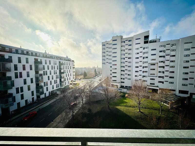 Weitblick auf die umliegenden Wohngebäude und eine belebte Straße an einem sonnigen Tag.