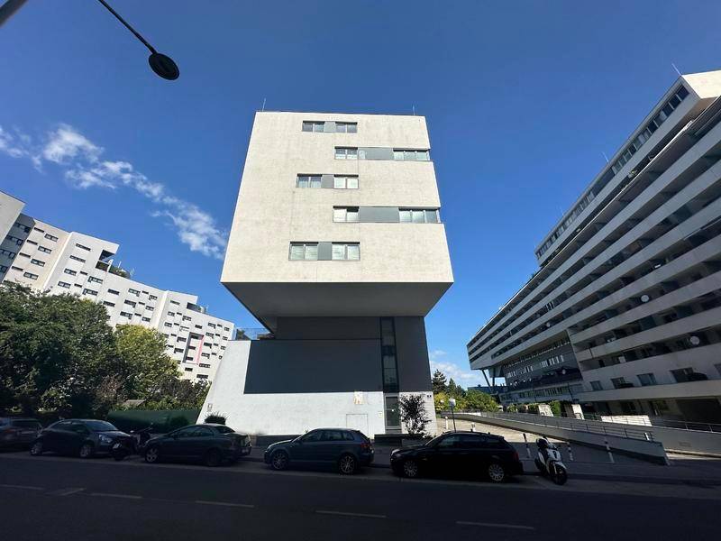 Ansicht der modernen Gebäudefassade von der Straße aus, mit klarem Himmel.