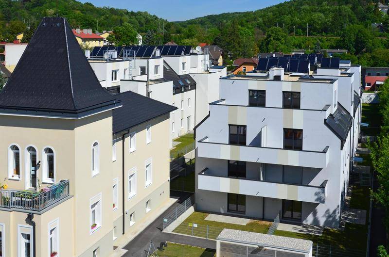 Gesamtansicht eines modernen Wohnkomplexes mit mehreren Gebäuden und Grünflächen.