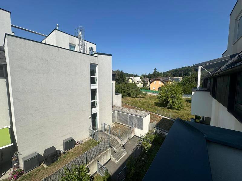 Außenansicht eines modernen Wohngebäudes mit Blick auf die umliegende grüne Landschaft.