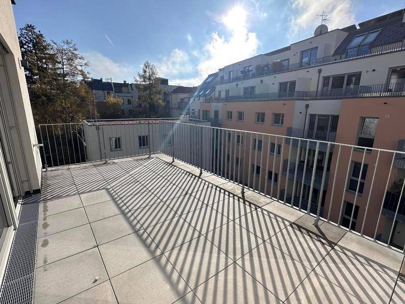 Sonniger Balkon mit Fliesenboden und Metallgeländer, ideal für entspannte Stunden im Freien.