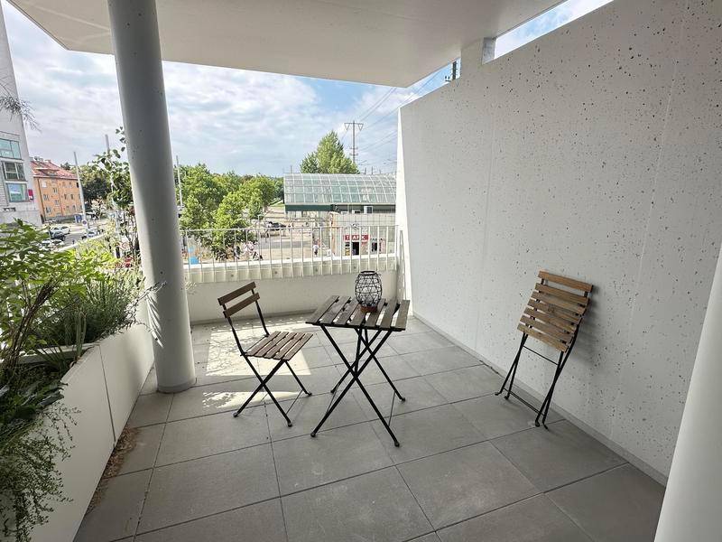 Kleiner Balkon mit Fliesenboden und einfacher Bestuhlung, bietet einen Blick auf die Umgebung.