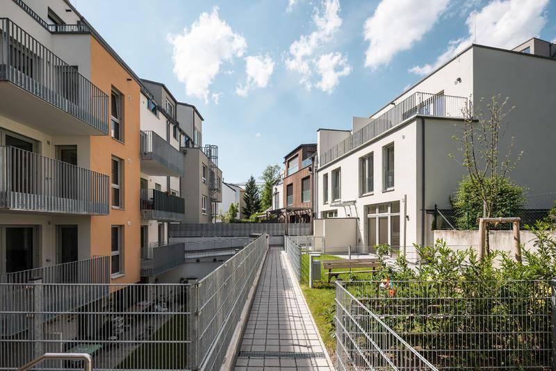 Moderne Wohngebäude mit barrierefreiem Zugang und Grünflächen im Innenhof.