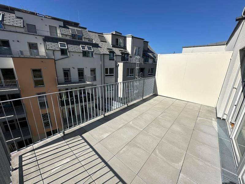 Helle Terrasse mit Fliesenboden und seitlichem Sichtschutz, ideal für entspannte Stunden im Freien.