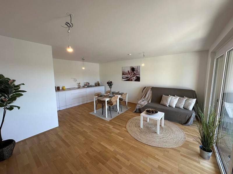 Offener Wohnbereich mit Sofa, Esstisch und Küchenzeile, ideal für modernes Wohnen.