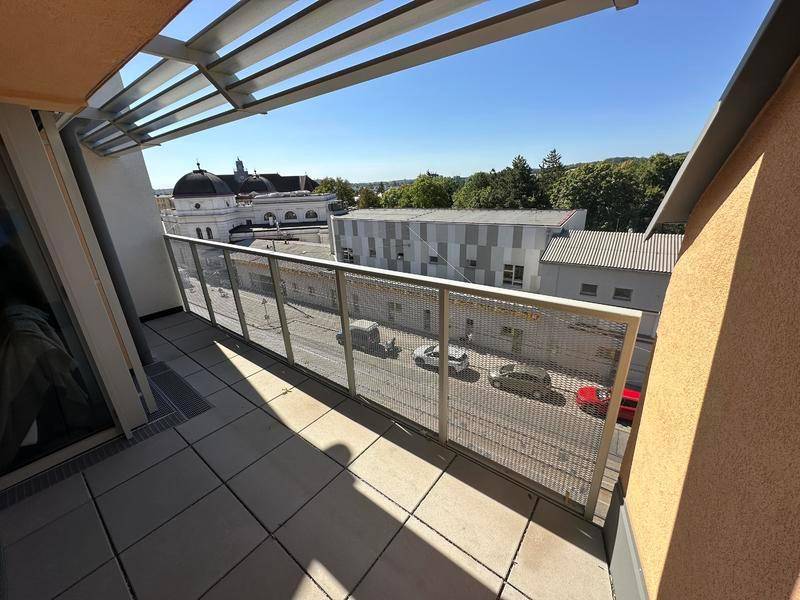 Heller Balkon mit Weitblick über die Stadt und umliegende Gebäude, perfekt für sonnige Tage.
