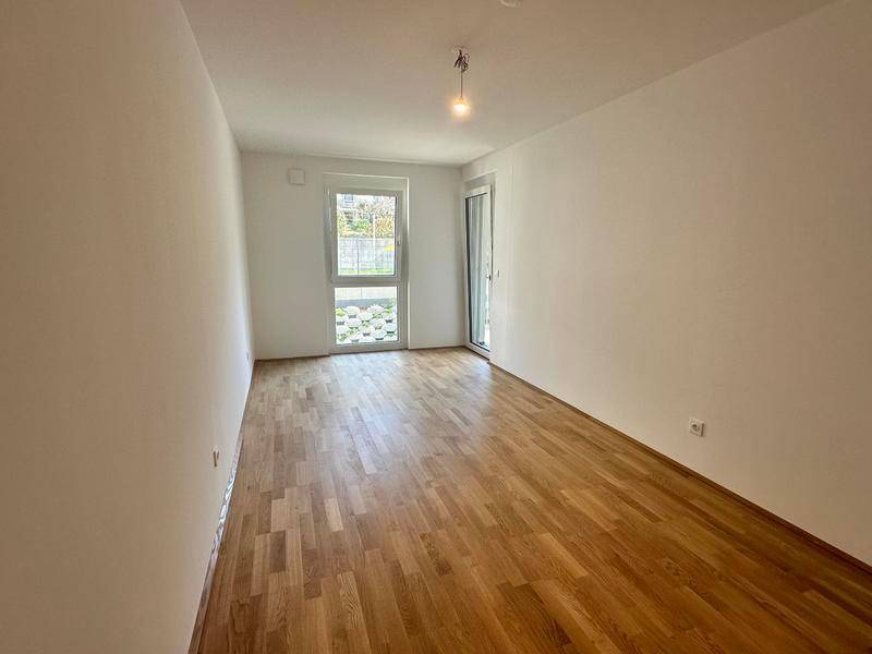 Helles Schlafzimmer mit Holzboden und großem Fenster für viel Tageslicht.
