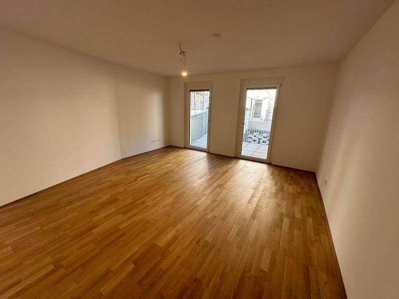 Geräumiges Schlafzimmer mit Holzboden und direktem Zugang zu zwei Balkonen oder Terrassen.