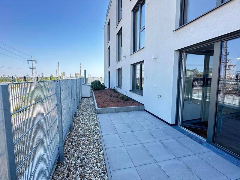 Kleine Terrasse im Erdgeschoss mit Kiesbeet und Blick auf die Umgebung.