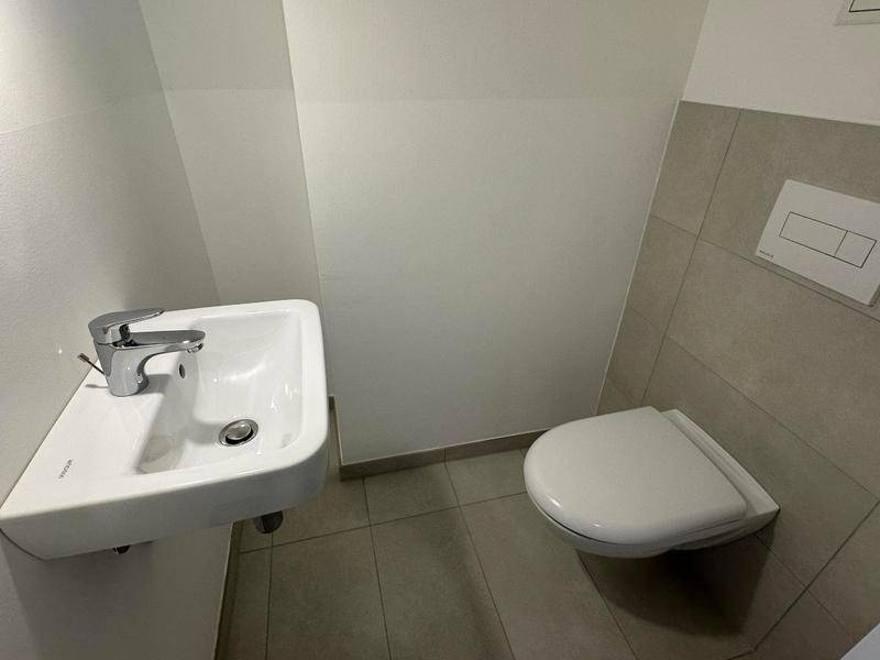 Kleines Gäste-WC mit wandhängender Toilette und einem kompakten Waschbecken.