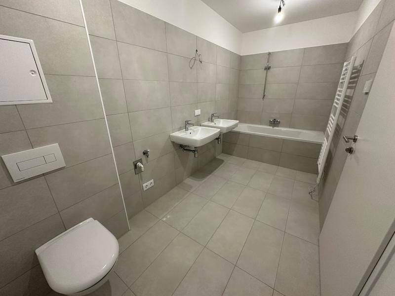 Modernes Badezimmer mit doppelten Waschbecken, Badewanne und beheiztem Handtuchhalter.