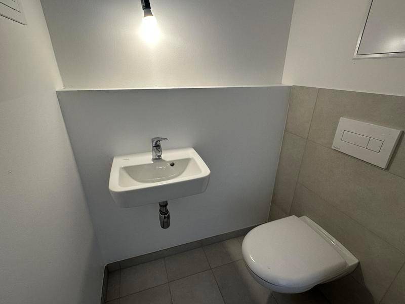 Kleines Gäste-WC mit Wand-WC und kompaktem Waschbecken.