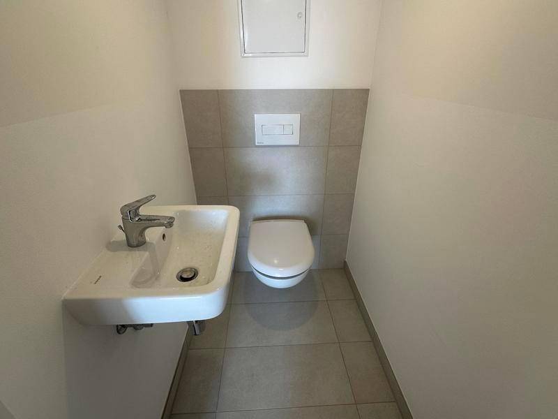 Kleines Gäste-WC mit modernem Wand-WC und kompaktem Waschbecken in hellem Design.