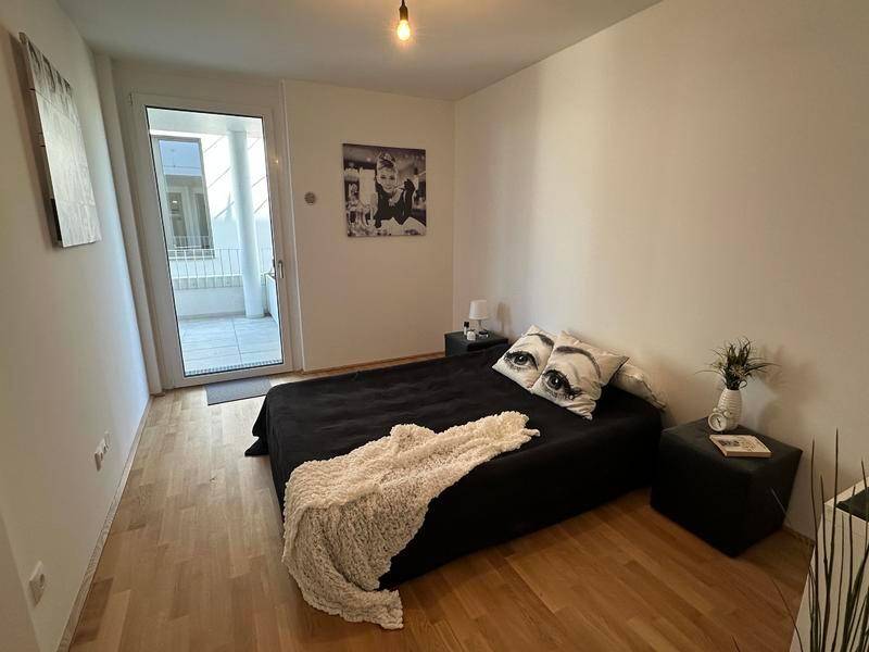 Gemütliches Schlafzimmer mit Holzboden und direktem Zugang zu einem Außenbereich.