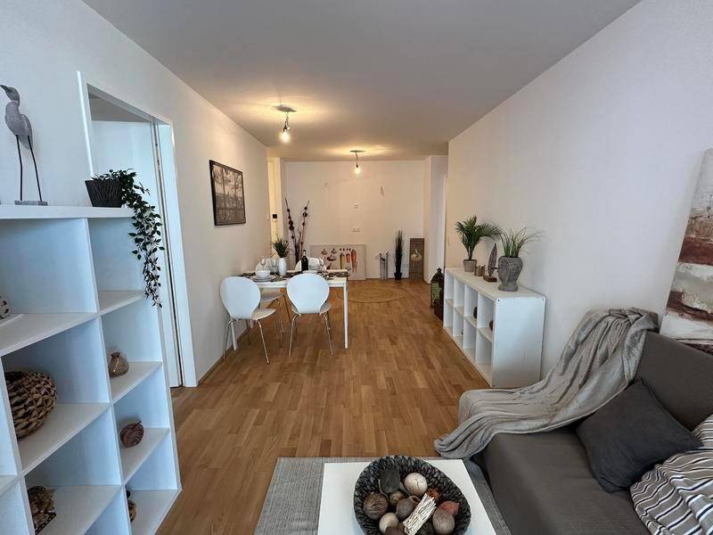Einladender Wohn- und Essbereich mit hellem Holzfußboden und zeitgemäßer Dekoration.