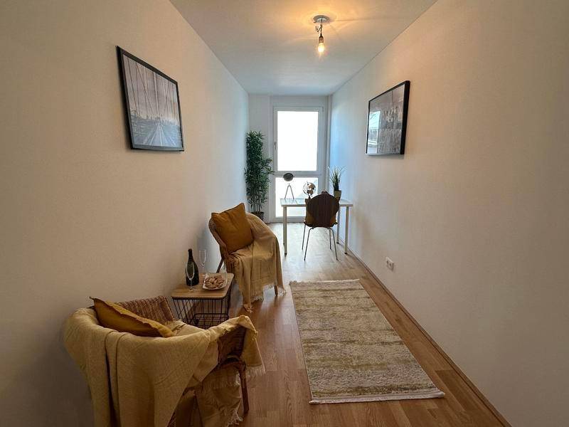 Helles Zimmer, ideal als Büro oder Gästezimmer, mit Holzboden und Fenster.