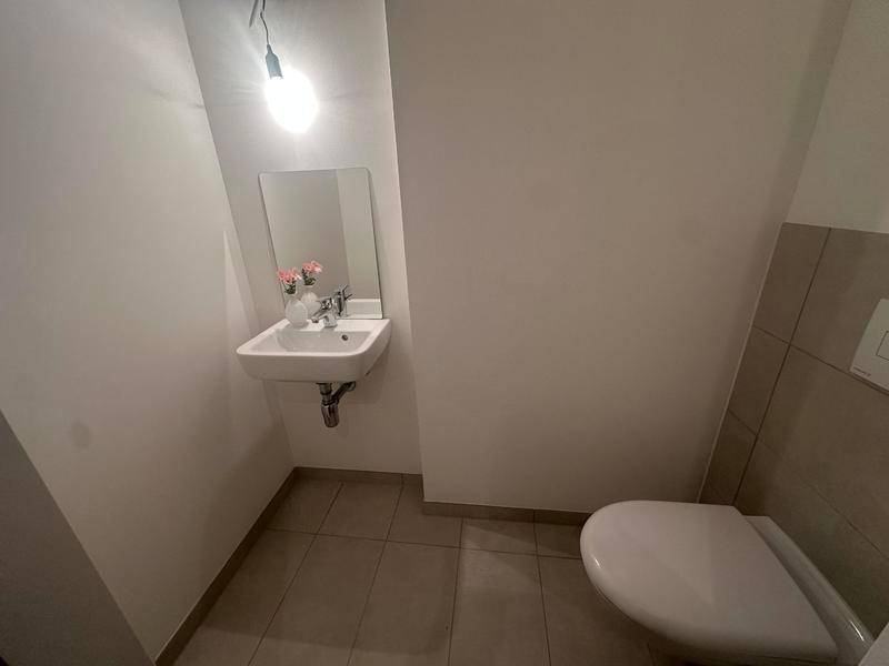 Kleines Gäste-WC mit Toilette und Handwaschbecken, praktisch und hell gefliest.