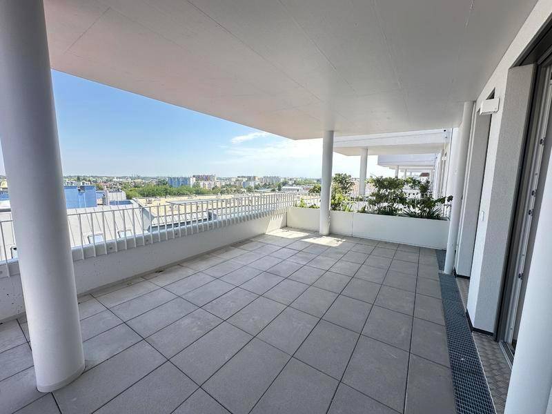 Geräumige Dachterrasse mit Fliesenboden und weitem Blick über die Stadt.