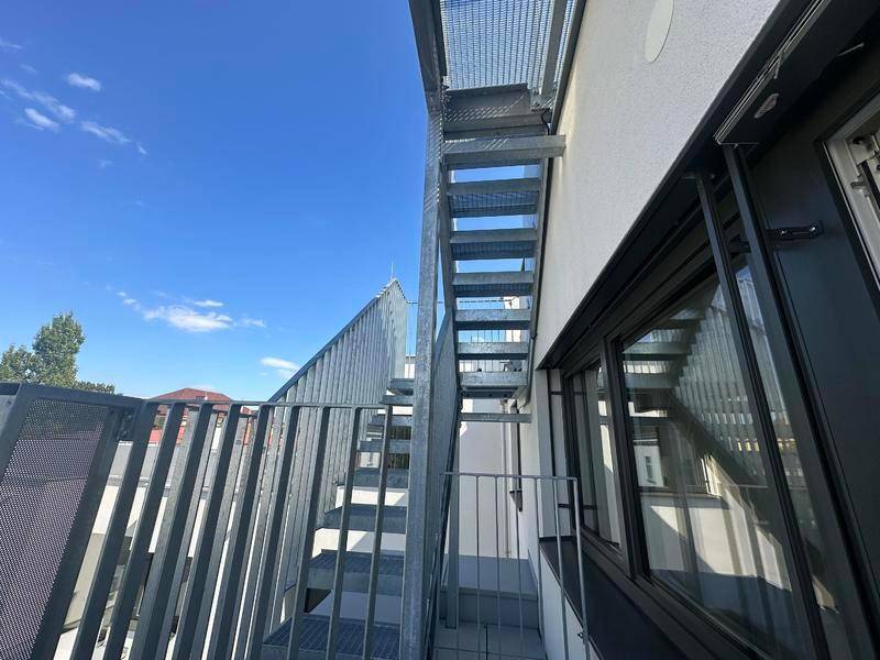 Externe Metalltreppe führt zu den oberen Ebenen des modernen Gebäudes.