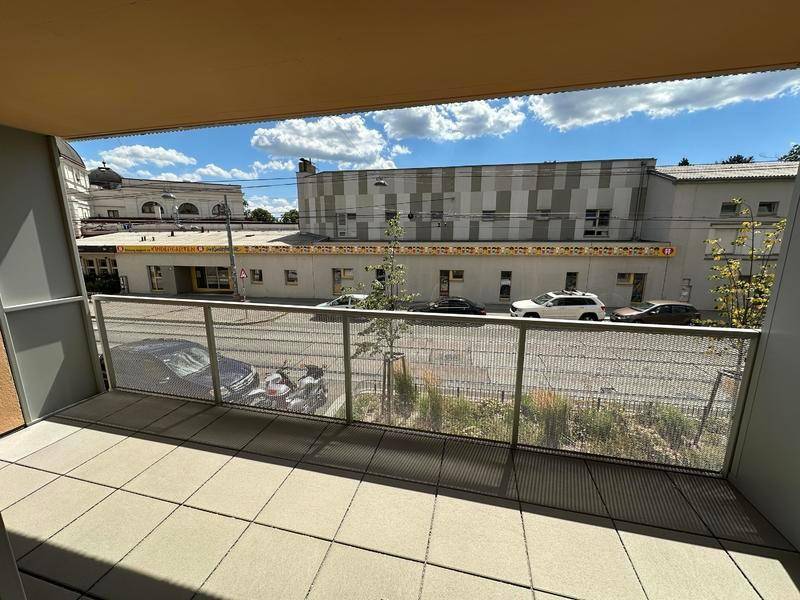 Geräumiger Balkon mit Fliesenboden und Blick auf die städtische Umgebung.