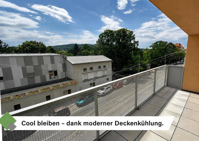 Geräumiger Balkon mit Fliesenboden und Metallgeländer, bietet einen Blick ins Grüne.