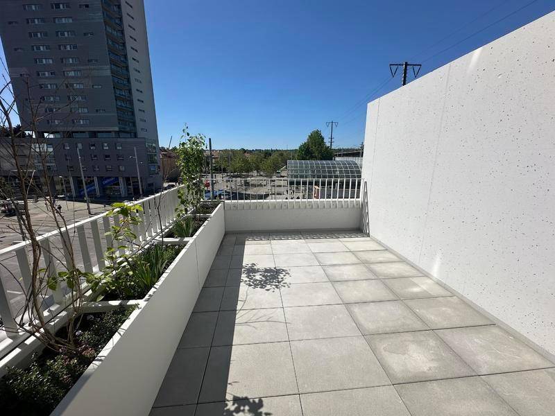 Helle Terrasse mit Fliesenboden und Pflanzenkübeln, bietet einen weiten Stadtblick.