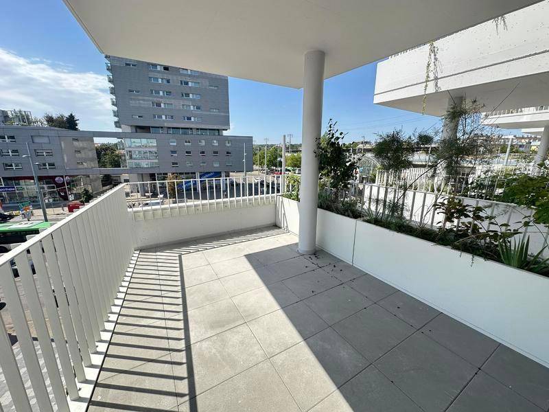 Heller Balkon mit Fliesenboden und Blick auf die städtische Umgebung und andere Gebäude.