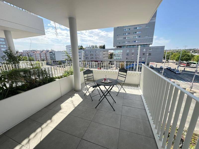 Gemütlicher Balkon mit kleinem Tisch und Stühlen, bietet einen Blick auf die Stadt.