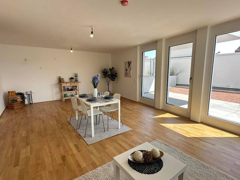 Lichtdurchfluteter Wohn- und Essbereich mit Holzboden, modernem Esstisch und Terrassenzugang.