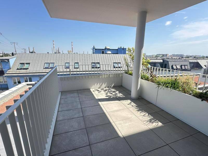 Geräumige Terrasse mit Fliesenboden und einem weiten Blick über die umliegenden Dächer und die Stadt.