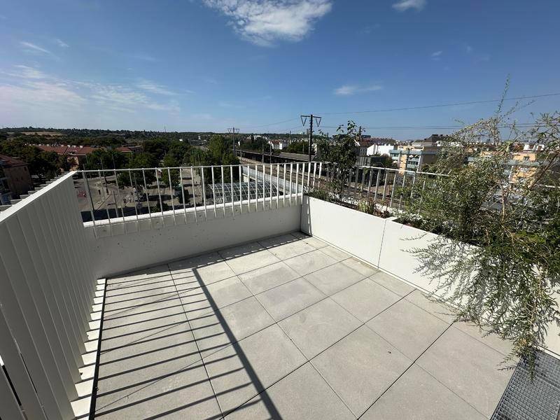 Geräumige Dachterrasse mit Fliesenboden und weitem Blick über die Stadt und Umgebung.