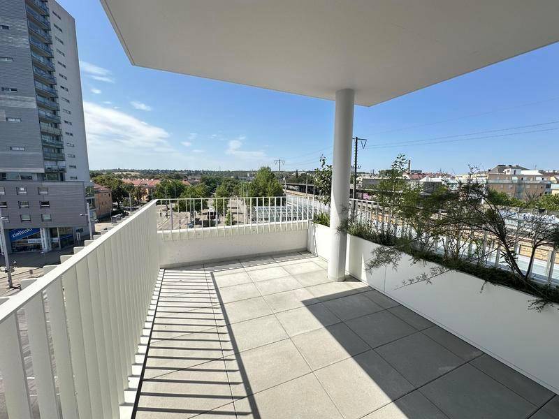 Geräumiger Balkon mit Fliesenboden und Blick auf die Stadt und die Umgebung.