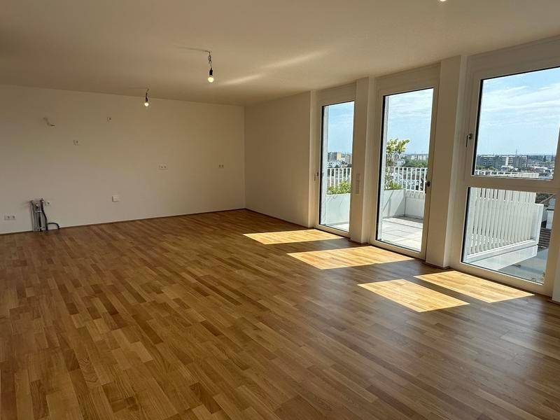 Lichtdurchfluteter Wohnbereich mit Holzboden und Zugang zur Außenterrasse.